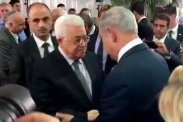 Palestinian Authority Chief Mahmpud Abbas shakes Israeli PM Banjamin Netanyahu's hand at Shimon Peres' funeral in al-Quds