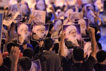 Protestors holding Sheikh Issa Qassem's photos