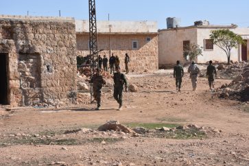 Syrian pro-government forces patrolling in a recently captured village in Aleppo