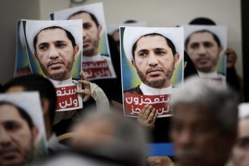 Bahraini men hold placards bearing the portrait of Sheikh Ali Salman, head of the Shiite opposition movement Al-Wefaq, during a protest on May 29, 2016 against his arrest, at Al wefaq headquarter building, in the village of Zinj on the outskirts of the capital Manama. / AFP PHOTO / MOHAMMED AL-SHAIKH