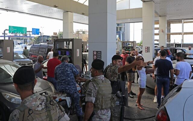 Lebanese soldiers are pictured at a petrol station in the capital Beirut on August 14, 2021, after soldiers were deployed to force several stations to reopen their doors. (Photo by ANWAR AMRO / AFP)