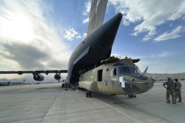 In this image provided by the Department of Defense, a CH-47 Chinook from the 82nd Combat Aviation Brigade, 82nd Airborne Division is loaded onto a U.S. Air Force C-17 Globemaster III at Hamid Karzai International Airport in Kabul, Afghanistan, Saturday, Aug, 28, 2021. (Department of Defense via AP)