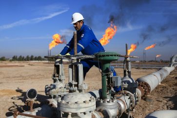 FILE - In this Jan. 12, 2017 file photo, a worker operates valves in Nihran Bin Omar field north of Basra, Iraq. The U.S. has signaled to Iraq it's willingness to extend sanctions waivers enabling the country to continue importing vital Iranian gas and electricity imports, three Iraqi officials said this week. The decision comes amid strained U.S.-Iraqi ties following last month's Washington-directed airstrike that killed a high-profile Iranian general on Iraqi soil. (AP Photo/Nabil al-Jurani, File)