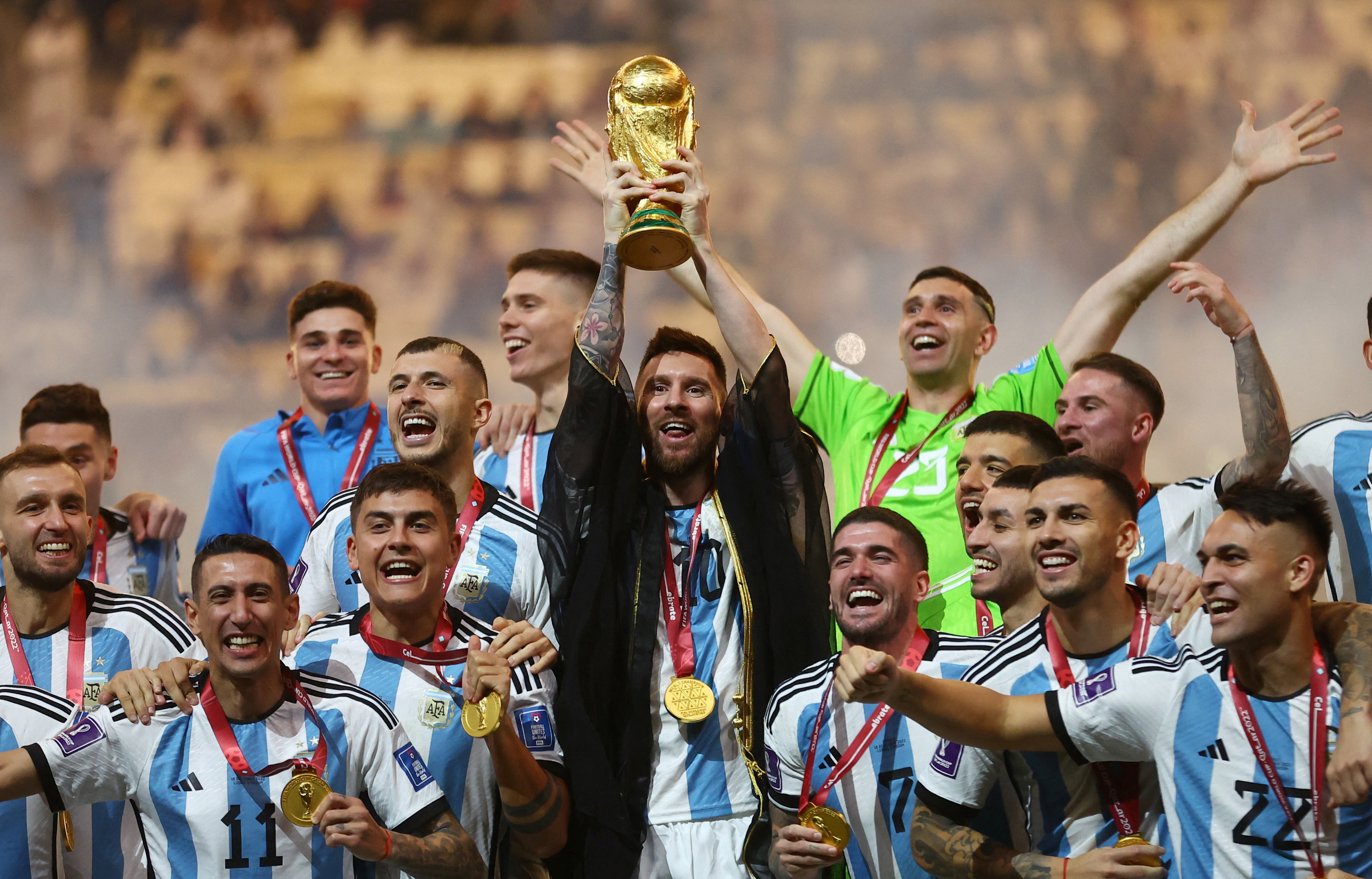 Soccer Football - FIFA World Cup Qatar 2022 - Final - Argentina v France - Lusail Stadium, Lusail, Qatar - December 18, 2022 Argentina's Lionel Messi lifts the World Cup trophy alongside teammates as they celebrate winning the World Cup REUTERS/Carl Recine