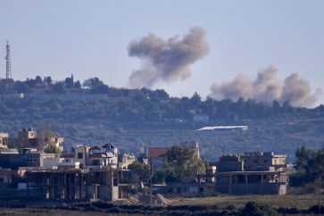 A picture taken from the southern Lebanese border town of Tayr Harfa shows smoke billowing near an Israeli outpost from rockets fired by Hezbollah on December 15, 2023 (photo by AFP).