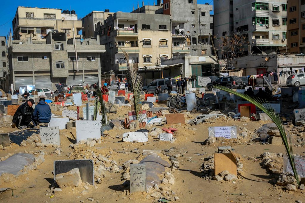 TOPSHOT - Placards indicating the names of people killed in Israeli bombardments are placed on shallow tombs at a makeshift cemetary in the vicinity of Al-Shifa Medical Complex in Gaza City on January 10, 2024. (Photo by AFP)