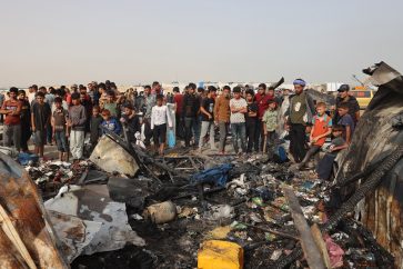 Palestinians gather at the site of an Israeli strike on a camp for internally displaced people in Rafah on May 27, 2024, amid ongoing battles between Israel and the Palestinian Hamas militant group. (Photo by Eyad BABA / AFP)