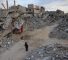 A woman walks past destroyed buildings in Khan Yunis in the southern Gaza Strip on October 17, 2024, amid the ongoing war between Israel and the Palestinian militant group Hamas in the besieged Palestinian territory. (Photo by BASHAR TALEB / AFP)