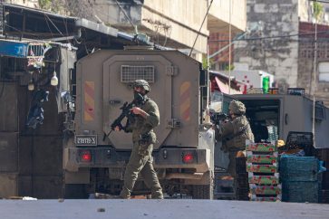 Israeli soldiers walk along a street during a military raid in the old town of Nablus in the occupied West Bank on February 16, 2025. (Photo by Jaafar ASHTIYEH / AFP)