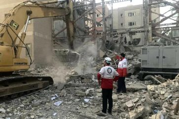 Members of Iranian Red Crescent Society’s rescue teams clearing debris at a building destroyed during an Israeli attack in Tehran (June 20, 2025).